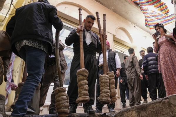 Men store torches to be used for the Persian New Year or Nowruz celebrations, in Akra, in Iraq's northern autonomous Kurdish region, Thursday, March 20, 2025. (AP Photo/Hadi Mizban)