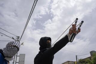 Un manifestante palestino usa una honda durante enfrentamientos con la policía fronteriza israelí en Burqa, Cisjordania, el martes 19 de abril de 2022. (AP Foto/Nasser Nasser)