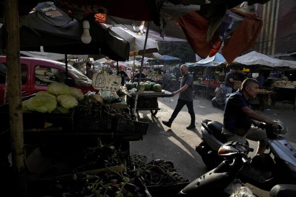 People shop at a busy popular market in Beirut, Lebanon, Monday, July 15, 2022. In Lebanon, where endemic corruption and political stalemate has crippled the economy, the World Food Program is increasingly providing people with cash assistance to purchase food, particularly after the devastating 2020 port blast that destroyed massive grain silos. (AP Photo/Bilal Hussein)