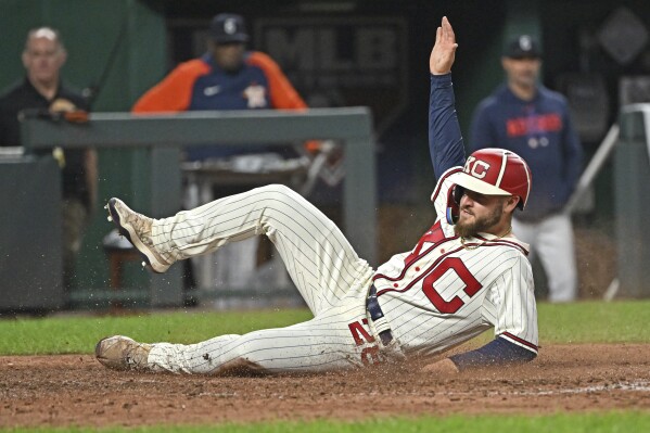 Kansas City Royals' Kyle Isbel slides across home plate to score during the seventh inning of a baseball game against the Houston Astros, Saturday, Sept. 16, 2023, in Kansas City, Mo. (AP Photo/Peter Aiken)