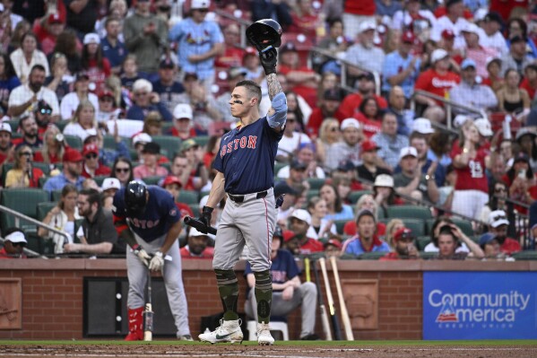 Boston Red Sox's Tyler O'Neill, center, acknowledges fans in his first game back at Busch Stadium prior to his at-bat in the second inning of a baseball game against the St. Louis Cardinals, Friday, May 17, 2024, in St. Louis. (AP Photo/Joe Puetz)