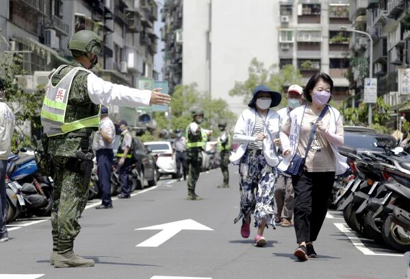 People are guided by Taiwan's soldiers to a basement shelter during the Wanan air raid drill in Taipei, Taiwan, Monday, July 25, 2022. Taiwan’s capital staged air raid drills Monday and its military mobilized for routine defense exercises, coinciding with concerns over a forceful Chinese response to a possible visit to the island by U.S. Speaker of the House Nancy Pelosi.(AP Photo/Chiang Ying-ying)