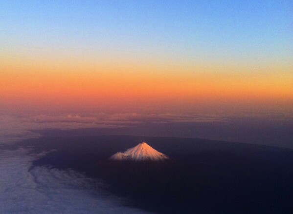 The New Zealand Mont Taranaki, also known as Mont Egmont, has a hot glow on the peak of snow, June 12, 2011. (AP photo / David Frampton, File)