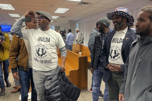 Ride-hailing drivers celebrate in Minneapolis, Thursday, March 7, 2024, immediately after Minneapolis City Council members voted to pass a measure that would increase wages to drivers of ride-hailing companies, including Uber and Lyft, to an equivalent of more than $15 an hour. Opponents say this may increase costs to customers and increase fears that Uber and Lyft will follow through on their threats to leave the area altogether. (AP Photo/Trisha Ahmed)