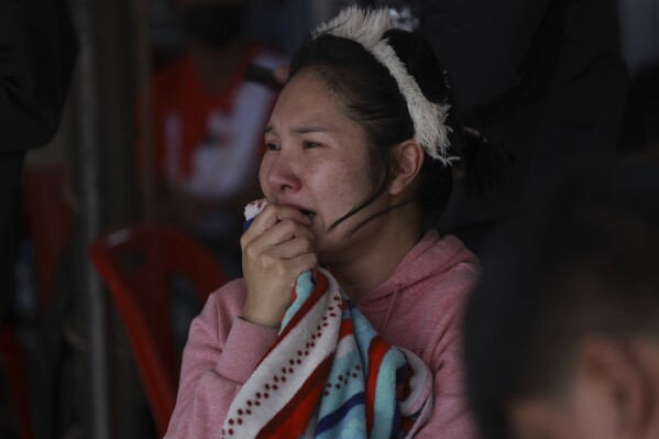 A woman reacts as she watches rescuers at the site of a high-rise building under construction that collapsed after a 7.7 magnitude earthquake in Bangkok, Thailand, Friday, March 28, 2025. (AP Photo/Wason Wanichakorn)