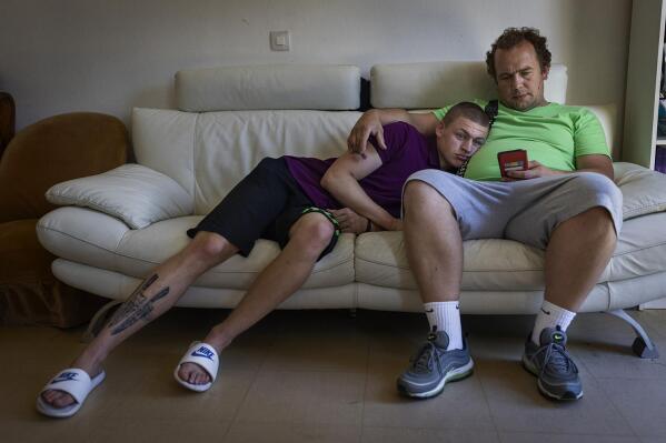 Timofey, left, and Denys Lopatkin watch TikTok videos from Ukraine in Loue, western France, Saturday, July 2, 2022. It took Timofey a couple of days before he could believe he was really back with his parents after being evacuated from Mariupol. After two months of negotiation and an initial objection from a senior Russian official, DPR authorities finally agreed to allow a volunteer with power of attorney from his mother to collect her children. (AP Photo/Jeremias Gonzalez)
