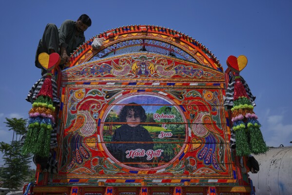 A worker gives the final touches to a newly refurbished truck at a yard for workshops in Rawalpindi, Pakistan Thursday, April 24, 2025. (AP Photo/Anjum Naveed)