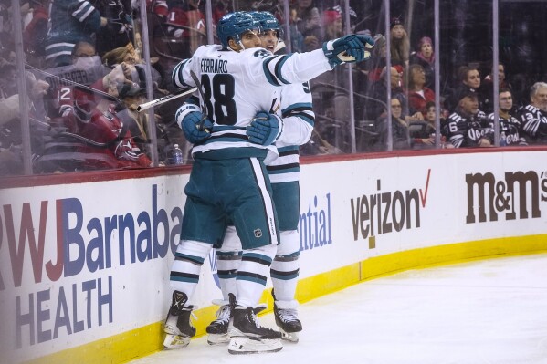 San Jose Sharks' Jacob MacDonald, right, embraces Mario Ferraro after scoring against the New Jersey Devils during the first period NHL hockey game Friday, Dec. 1, 2023, in Newark, N.J. (AP Photo/Bebeto Matthews)