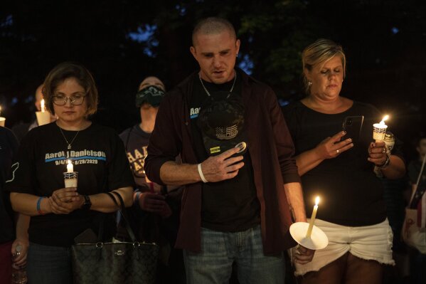 People hold candles during a vigil Saturday, Sept. 5, 2020, in Vancouver, Wash., for Aaron "Jay" Danielson, a supporter of Patriot Prayer who was shot and killed a week ago in Portland, Ore. (AP Photo/Paula Bronstein)