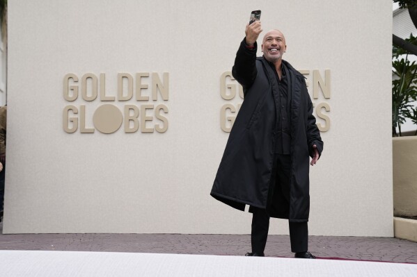 Jo Koy takes a selfie as he rolls out the red carpet during the Golden Globe Awards Press Preview at the Beverly Hilton on Thursday, Jan. 4, 2024, in Beverly Hills, Calif. (AP Photo/Ashley Landis)