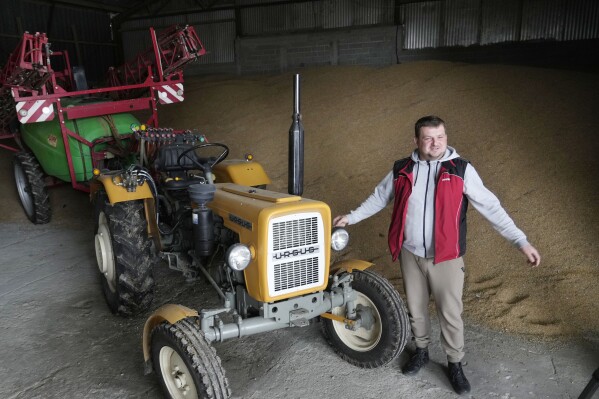 Piotr Korycki, a 34-year-old Polish farmer, stands in a warehouse filled with grain on his farm in Cywiny Wojskie, Poland, on Monday March 18, 2024. Korycki has been organizing protests of farmers in Poland that have been taking place for the past three months in Poland. They are among the Europe-wide protests by farmers angry about imports from Ukraine which they say are driving down prices. They are also angry about EU climate policies which they say will create more administrative work and further financial burdens. (AP Photo/Czarek Sokolowski)