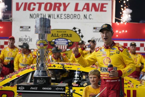 2024年5月19日，星期日，北卡罗来纳州北威尔克斯博罗市北威尔克斯博罗赛道，乔伊·洛加诺（Joey Logano）在赢得NASCAR全明星汽车赛冠军后，在胜利巷（Victory Lane）与奖杯合影。（美联社照片/Chuck Burton）