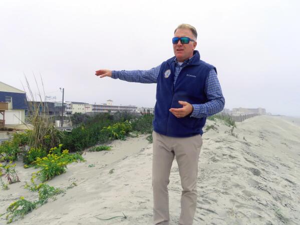 FILE - Mayor Patrick Rosenello stands atop a recently repaired dune in North Wildwood, N.J., on Oct. 25, 2022. New Jersey filed a lawsuit Tuesday, Dec. 6, 2022 suing one of its shore towns that repaired damage from an October storm in defiance of a state order not to do so. (AP Photo/Wayne Parry, File)