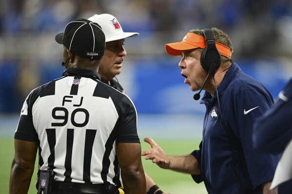 Denver Broncos head coach Sean Payton talks with side judge Anthony Flemming (90) and referee John Hussey during the second half of an NFL football game against the Detroit Lions, Saturday, Dec. 16, 2023, in Detroit. (AP Photo/David Dermer)