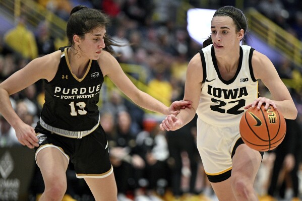 Iowa's Caitlin Clark (22) tries to get around Purdue Fort Wayne defender Amellia Bromenschenkel (13) during the first half of an NCAA college basketball game, Friday, Nov. 24, 2023, in Estero, Fla. (AP Photo/Chris Tilley)