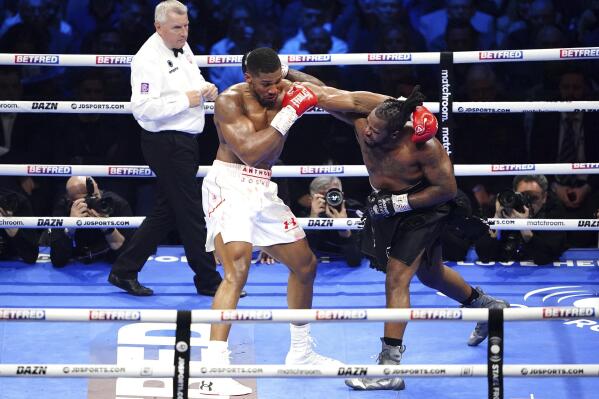 Anthony Joshua, left, punches Jermaine Franklin during a heavyweight boxing match at The O2, Saturday, April 1, 2023 in London. (Zac Goodwin/PA via AP)