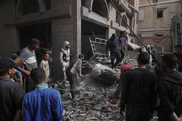 Palestinians inspect the damage caused by an Israeli army airstrike in Khan Younis, Gaza Strip, Tuesday, April 22, 2025. (AP Photo/Abdel Kareem Hana)