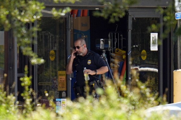 Law enforcement officials continue their investigation at a Dollar General Store that was the scene of a mass shooting, Sunday, Aug. 27, 2023, in Jacksonville, Fla. (AP Photo/John Raoux)