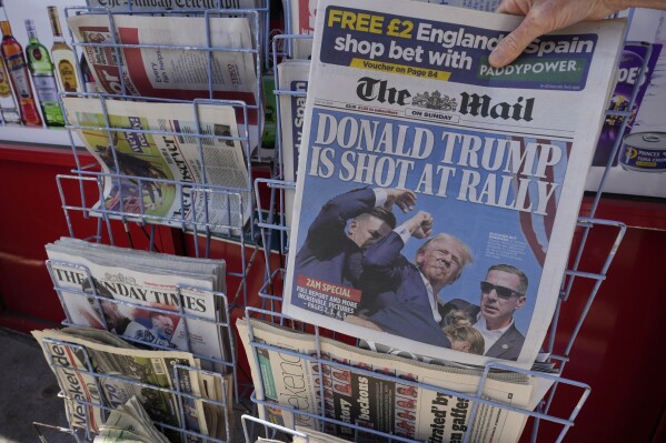 A woman buys a copy of the British Mail on Sunday newspaper at a newsagents in London, Sunday, July 14, 2024, showing the reaction to events at former President Trump's campaign rally in Butler, Pennsylvania. Donald Trump's campaign says he is "fine" after what law enforcement officials are treating as an assassination attempt during a rally in Butler, Pennsylvania. (ĢӰԺ Photo/Kirsty Wigglesworth)