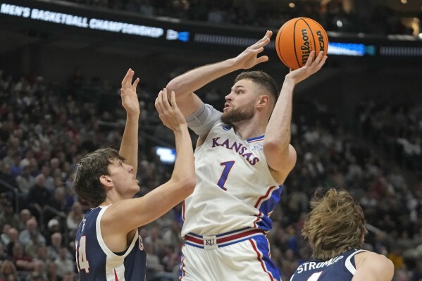 FILE - Kansas center Hunter Dickinson (1) shoots as Gonzaga forward Braden Huff (34) defends during the first half of a second-round college basketball game in the NCAA Tournament in Salt Lake City, Saturday, March 23, 2024. Kansas star center Hunter Dickinson on Friday, April 26, announced he would return for another season with the Jayhawks.(AP Photo/Rick Bowmer, File)