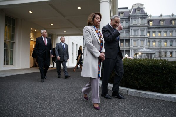 
              House Democratic leader Rep. Nancy Pelosi of California, and Senate Minority Leader Chuck Schumer, D-N.Y., walk to speak with reporters after a meeting with President Donald Trump on border security at the White House, Wednesday, Jan. 2, 2019, in Washington. (AP Photo/Evan Vucci)
            