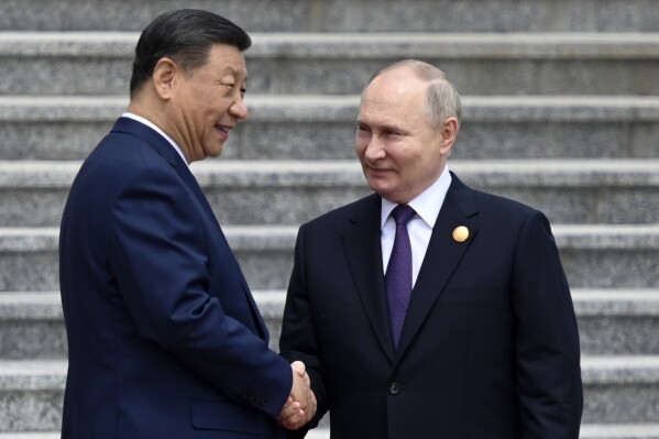Los presidentes de China, Xi Jinping (izquierda), y Rusia, Vladímir Putin, se estrechan la mano durante su encuentro el 16 de mayo de 2024, en Beijing, China. (Sergei Bobylev, Sputnik, foto compartida del Kremlin vía AP)