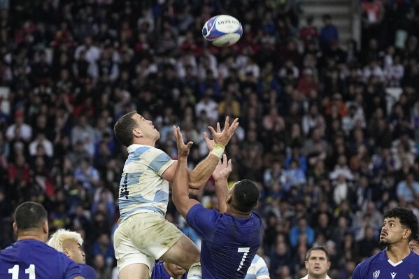 Argentina's Emiliano Boffelli, top left, with Samoa's Fritz Lee jumps for the ball during the Rugby World Cup Pool D match between Argentina and Samoa at the Stade Geoffroy Guichard in Saint-Etienne, France, Friday, Sept. 22, 2023. (AP Photo/Laurent Cipriani)