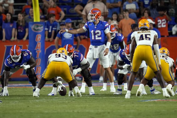 FILE - Florida quarterback Micah Leon (12) call signals against McNeese State during the second half of an NCAA college football game, Saturday, Sept. 9, 2023, in Gainesville, Fla. Micah Leon's journey to the NFL was far from normal. He was a walk-on quarterback at North Carolina State, UConn and Florida. His entire collegiate career spans seven years and includes two mop-up appearances. He completed 12 of 16 passes for 78 yards, barely enough to create a highlight reel. So getting a tryout with the Miami Dolphins during rookie minicamp this weekend was some feat.(AP Photo/John Raoux, File)