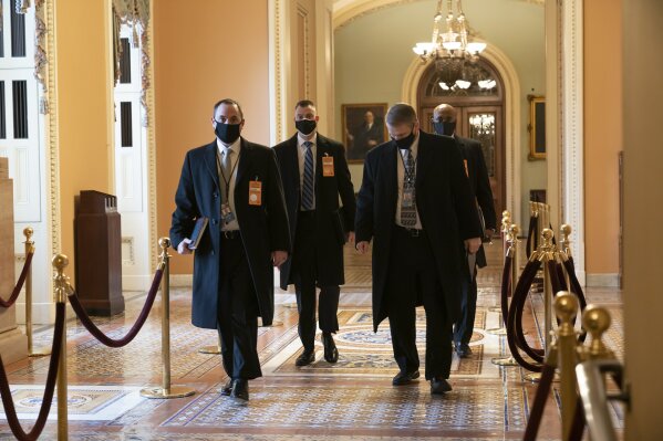 Security officials survey the Capitol in Washington, Monday, Jan. 11, 2021, ahead of the scheduled presidential inauguration. House Speaker Nancy Pelosi, D-Calif., is calling for congressional action to rein in President Donald Trump after inciting last week's deadly assault on the U.S. Capitol. (AP Photo/J. Scott Applewhite)