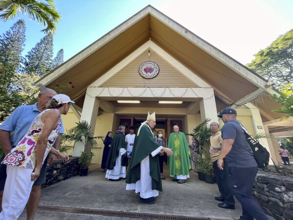 Most Rev. Clarence "Larry" Silva, the Bishop of Honolulu, greets parishioners after Mass at Sacred Hearts Mission Church in Kapalua, Hawaii, Sunday, Aug. 13, 2023. Sacred Hearts Mission Church hosted congregants from Maria Lanakila Catholic Church in Lahaina, including several people who lost family members in fires that burned most of the Maui town days earlier. (AP Photo/Haven Daley)