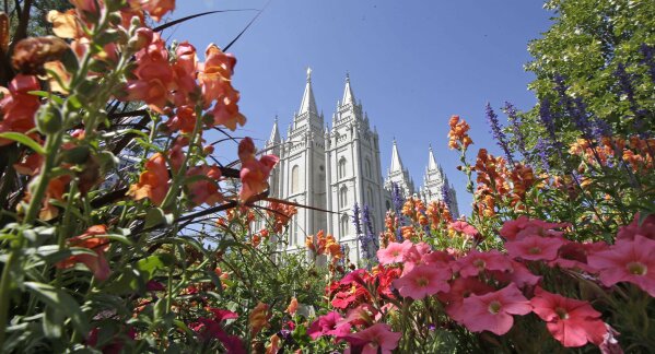 
              FILE - This Aug. 4, 2015 file photo, flowers bloom in front of the Salt Lake Temple, at Temple Square, in Salt Lake City. The Church of Jesus Christ of Latter-day Saints is repealing rules unveiled in 2015 that banned baptisms for children of gay parents and made gay marriage a sin worthy of expulsion. The surprise announcement Thursday, April 4, 2019, by the faith widely known as the Mormon church reverses rules that triggered widespread condemnations from LGBTQ members and their allies. (AP Photo/Rick Bowmer, File)
            