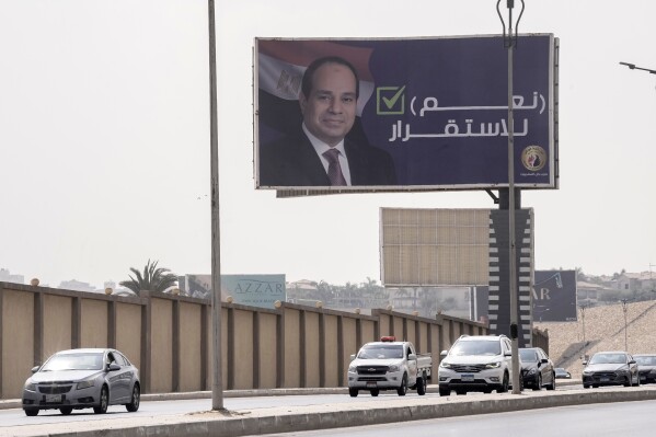 FILE - Vehicles pass under a billboard supporting Egyptian President Abdel Fattah el-Sissi for the coming presidential elections, erected by Egypt's political party of Homat Watan, the Protectors of the Nation, in Cairo, Egypt, on Sept. 4, 2023. Arabic reads, "yes for stability." Egypt will hold a presidential election over three days in December, officials announced Monday, Sept. 25, 2023 with President Abdel Fattah el-Sissi highly likely to prolong his stay in power until 2030. (AP Photo/Amr Nabil, File)