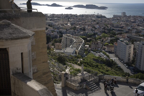 People visit the Notre Dame de la Garde Basilica in Marseille, southern France, Friday, April 19, 2024. (AP Photo/Daniel Cole)