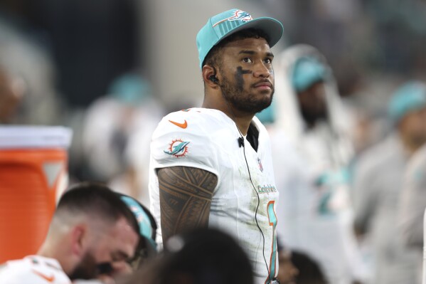 Miami Dolphins quarterback Tua Tagovailoa (1) watches from the sideline during the first half of an NFL preseason football game against the Jacksonville Jaguars, Saturday, Aug. 26, 2023, in Jacksonville, Fla. (AP Photo/Gary McCullough)