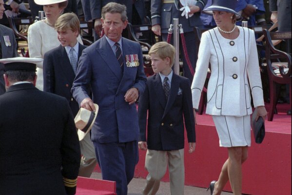 FILE - Prince Charles and Princess Diana escort their children William, left, and Harry, right, onto the Royal stand as VJ-Day commemorations got underway at Buckingham Palace in London, Saturday Aug. 19, 1995. Prince Harry alleged Thursday, March 21, 2024, that the publisher of The Sun tabloid unlawfully intercepted phone calls of his late mother, Princess Diana, and father, now King Charles III, as he sought to expand his privacy invasion lawsuit against News Group Newspapers. (AP Photo/Jacqueline Arzt, File)