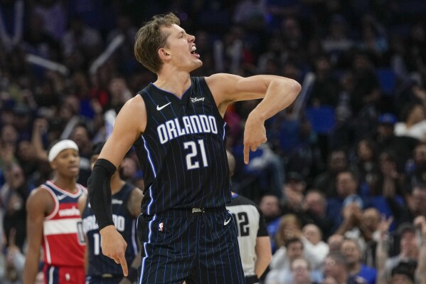 Orlando Magic center Moritz Wagner (21) celebrates with fans after making a shot and shooting a free throw for a 3-point play during the second half of the team's NBA basketball game against the Washington Wizards, Friday, Dec. 1, 2023, in Orlando, Fla. (AP Photo/John Raoux)