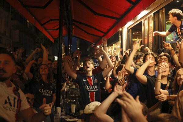 PSG supporters celebrate one of their team's goal outside a cafe during the Champions League final soccer match between Paris Saint-Germain and Inter Milan, Saturday, May 31, 2025 in Paris. (AP Photo/Thomas Padilla)