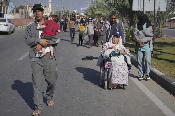 Palestinians flee to the southern Gaza Strip on Salah al-Din Street in Bureij, Gaza Strip, Tuesday, Nov. 7, 2023. (AP Photo/Hatem Moussa)