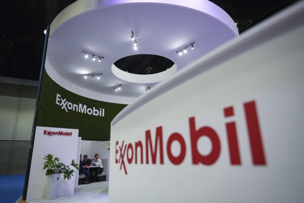 FILE - Delegates meet at the Exxon Mobil booth during the LNG2023 conference in Vancouver, British Columbia, Tuesday, July 11, 2023. Exxon Mobil reports their earnings Friday, April 26, 2024. (Darryl Dyck/The Canadian Press via AP, File)