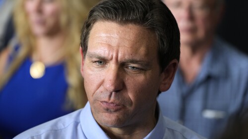 FILE - Republican presidential candidate Florida Gov. Ron DeSantis speaks to reporters at U.S. Rep. Zach Nunn's Annual BBQ, Saturday, July 15, 2023, in Ankeny, Iowa. DeSantis is cutting campaign staff as he struggles to catch former President Donald Trump in the GOP’s crowded primary contest while facing sudden financial pressure. DeSantis let go fewer than 10 paid staffers late last week. That's according to a DeSantis aide granted anonymity to discuss internal campaign strategy. (AP Photo/Charlie Neibergall, File)