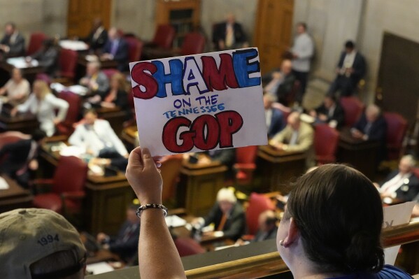 Laura Seay holds a sign over the House floor during a special session of the state legislature on public safety Thursday, Aug. 24, 2023, in Nashville, Tenn. (AP Photo/George Walker IV)