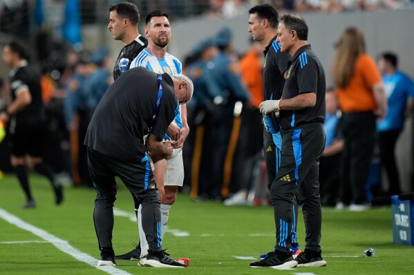  A team assistant massages Argentina's Lionel Messi during a Copa America Group A soccer match against Chile in East Rutherford, N.J., Tuesday, June 25, 2024. (AP Photo/Julia Nikhinson)