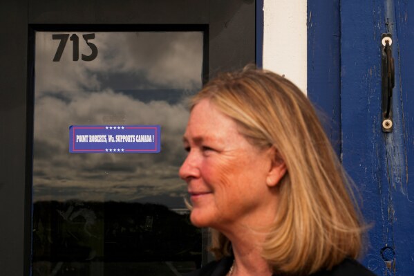 Tamra Hansen, a dual citizen of Canada and the United States who runs two of the three restaurants in town, poses for a portrait outside The Pier, Monday, March 17, 2025, in Point Roberts, Wash. (AP Photo/Lindsey Wasson)
