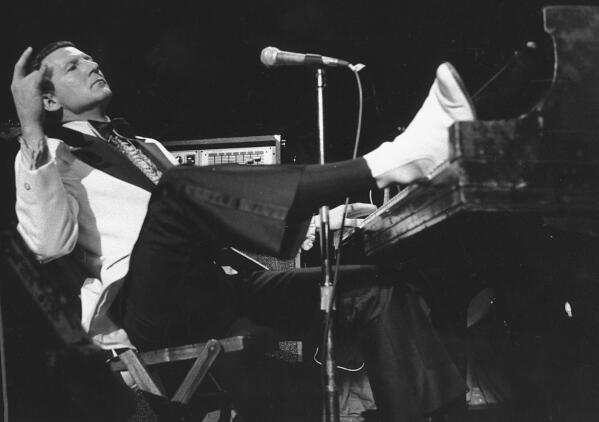 CORRECTS LOCATION OF DEATH TO DESOTO COUNTY, MISSISSIPPI - FILE - Jerry Lee Lewis props his foot on the piano as he lays back and acknowledges the applause of fans during the fifth annual Rock 'n' Roll Revival at New York's Madison Square Garden on March 14, 1975. Spokesperson Zach Furman said Lewis died Friday morning, Oct. 28, 2022, at his home in DeSoto County, Miss., south of Memphis, Tenn. He was 87. (AP Photo/Rene Perez, File)