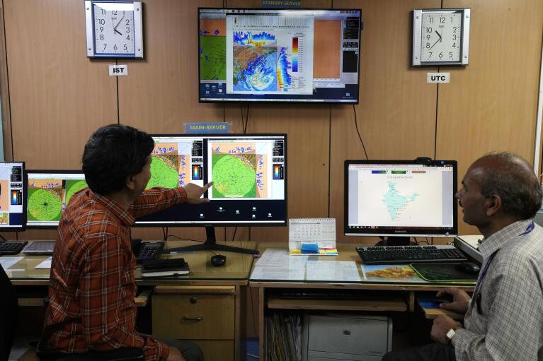 An employee of the India Meteorological Department shows the current movement of rain clouds over Delhi on a radar in New Delhi, India, Friday, March 17, 2023. The India Meteorological Department as well as the state of Kerala have increased infrastructure for cyclone warnings since Cyclone Ockhi in 2017, which killed about 245 fishermen out at sea. (AP Photo/Manish Swarup)