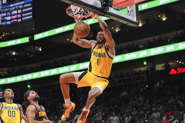 Indiana Pacers forward Obi Toppin (1) scores as Atlanta Hawks guard Patty Mills (8) defends during the second half of an NBA basketball game Friday, Jan. 12, 2024, in Atlanta. (AP Photo/John Bazemore)