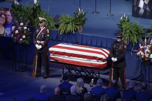 This image taken from video shows the law enforcement standing next to the casket of Hamilton County Special Deputy Larry Ray Henderson Jr. at the Cintas Center on Friday, May 9, 2025 in Cincinnati, Ohio. (WCPO via AP)