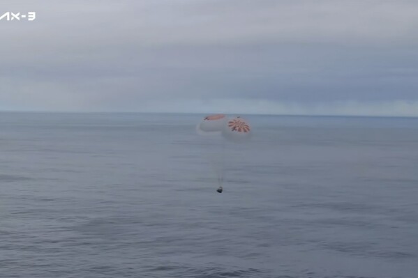 This photo provided by Axiom Space shows a SpaceX capsule parachuting into the Atlantic Ocean on Friday, Feb. 9, 2024 off the Florida coast. Astronauts from Turkey, Italy and Sweden returned to Earth on Friday, ending a private three-week mission to the International Space Station. (Axiom Space via AP)