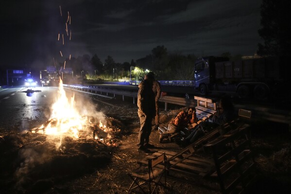 FILE - Farmers spend the night at a highway barricade in Aix-en-Provence, southern France, Tuesday, Jan. 30, 2024. (AP Photo/Daniel Cole, File)