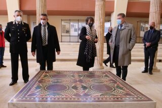 Authorities stand around a 1.5 square meter colorful mosaic dating back to 40 A.D. and belonging to the flooring of Caligula’s lavish ceremonial ships, that was found thanks to a joint police operation in the rooms of a Manhattan house and returned to the museum of Nemi, near Rome, Thursday, March 11, 2021. In September 2017, the department for cultural heritage protection of the Italian Carabinieri police, in collaboration with New York district attorney, managed to sequester the mosaic from the house of an Italian-American woman who brought it in the states illegally many decades earlier. (AP Photo/Paolo Santalucia)